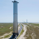 Imagen para el artículo titulado SpaceX monta el propulsor de la Starship en su plataforma de lanzamiento con dos enormes brazos robóticos